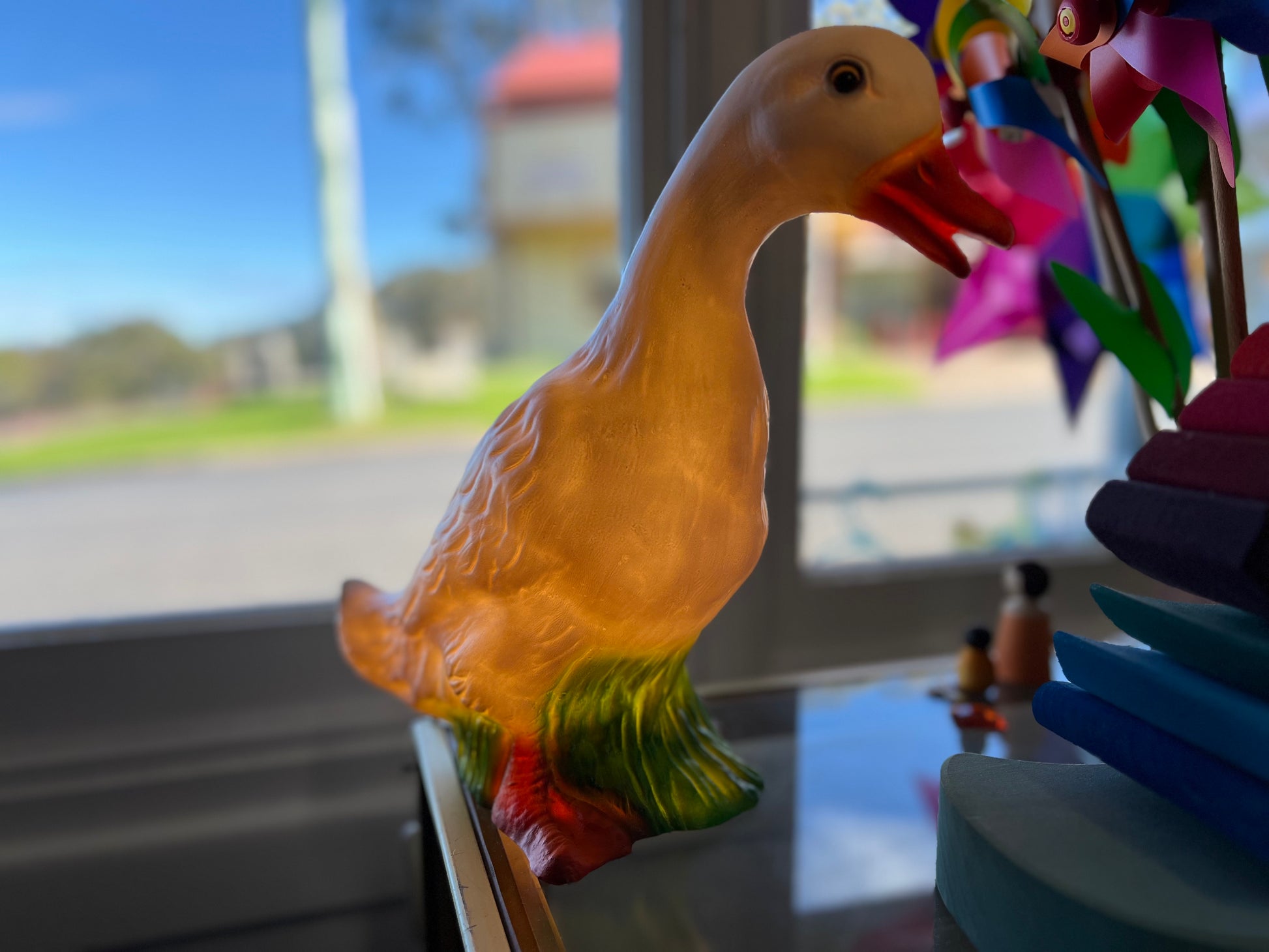 A duck shaped nightlight sits on a countertop.  The lamp is on and gives off a soft warm yellow glow.