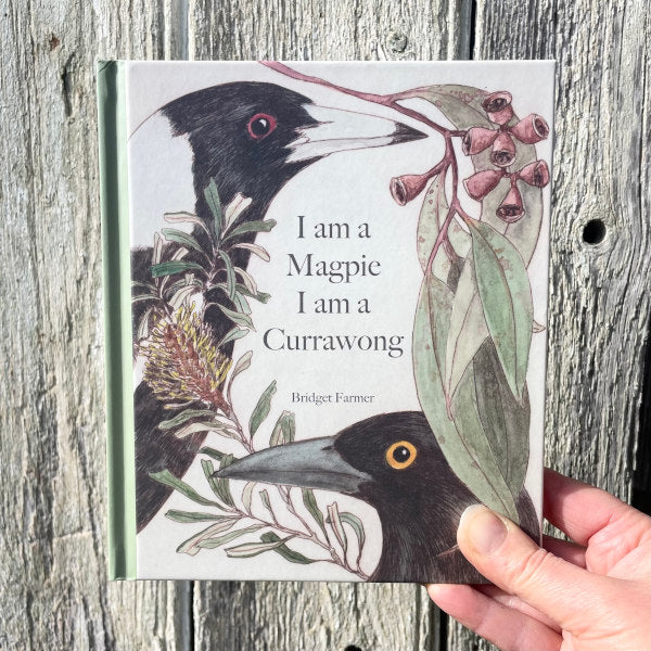 front cover of book with a magpie and currawong face, gum leaves and native australian flowers also feature