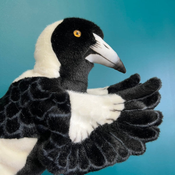 side view of plush magpie puppet he is black and white with a shiny beady eye