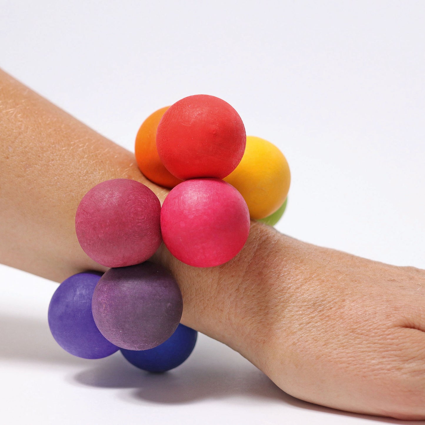 A wooden bead grasper is worn on a wrist like a bracelet